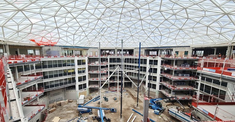 Interior view of a modular construction site under a geometric dome structure, illustrating modern construction techniques.